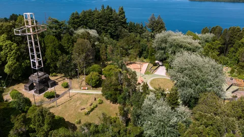 Vista aérea del Cerro Philippi en Puerto Varas, con la cruz monumental de acero, las pasarelas nuevas del parque y el lago Llanquihue al fondo