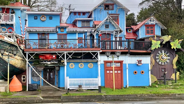 Fachada azul del Museo Pablo Fierro en la costanera de Puerto Varas, con el reloj cucú gigante y la proa de un barco