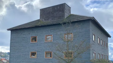 Edificio de tablas azules del antiguo Molino Machmar, hoy Centro de Arte Molino Machmar, en Puerto Varas
