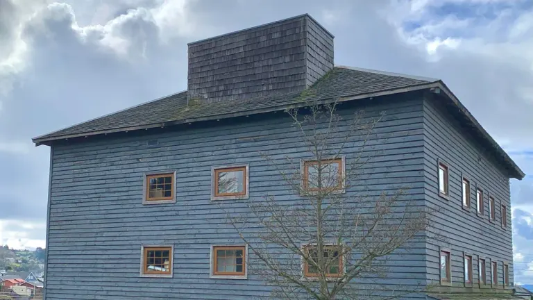 Edificio de tablas azules del antiguo Molino Machmar, hoy Centro de Arte Molino Machmar, en Puerto Varas