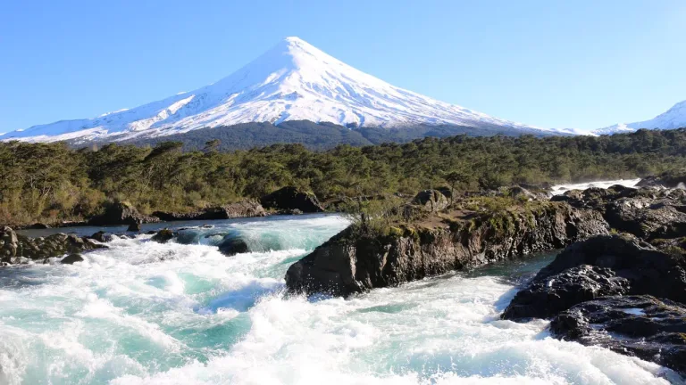 Rápidos del río Petrohué sobre roca volcánica con el volcán Osorno nevado al fondo, en el Parque Nacional Vicente Pérez Rosales